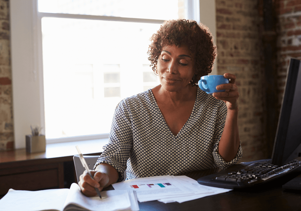 woman at desk writing what is the difference between resignation and early retirement
