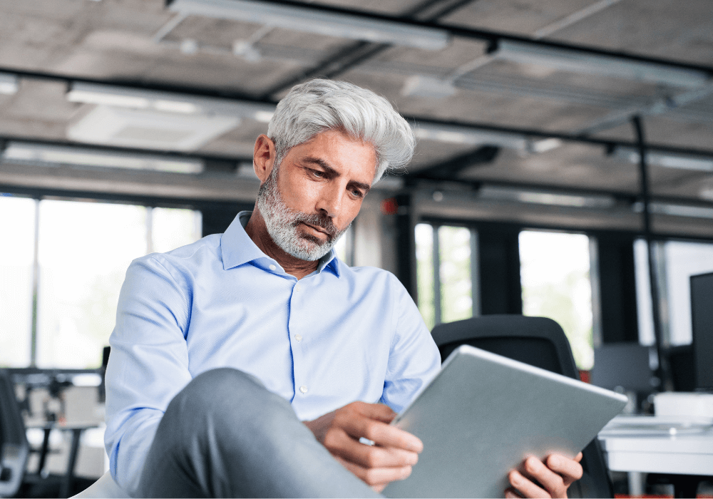 man reading on tablet what is the difference between resignation and early retirement