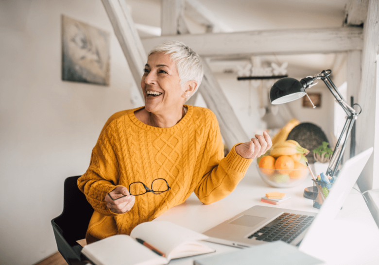 senior woman smiling at desk hobbies for women over 50