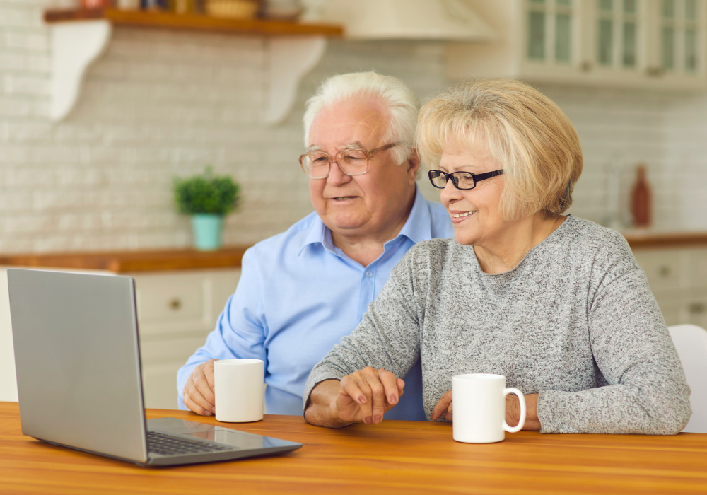 older couple sitting looking a computer How to Cope with Note Seeing Your Grandchildre