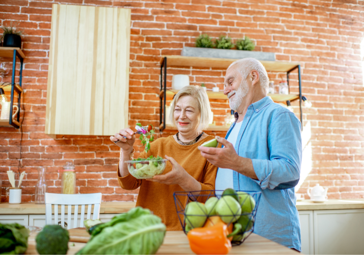 Modern brick kitchen, couple preparing salad at counter, wide view, natural light, editorial travel photo, people present.
