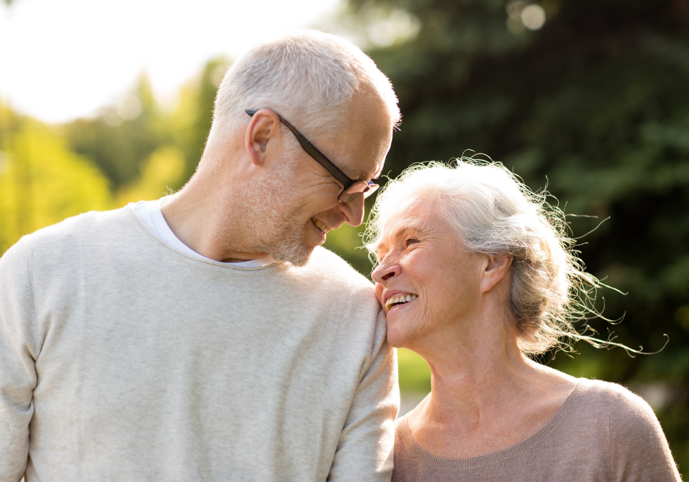 Garden, older couple embracing, close-up composition, warm sunlight, editorial travel photo, two people.
