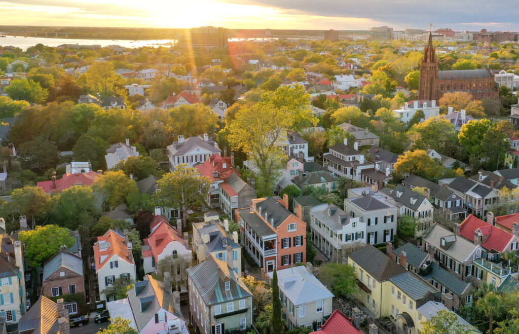 Historic neighborhood, large church, colorful homes and leafy streets, sunset warm glow, editorial travel photo, no people.