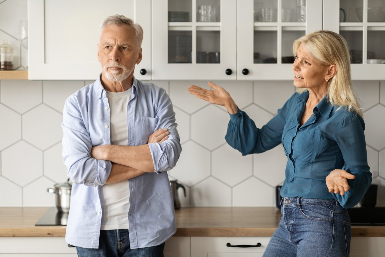 Kitchen, man and woman in confrontation, mid-shot composition, natural light, documentary style, two people.