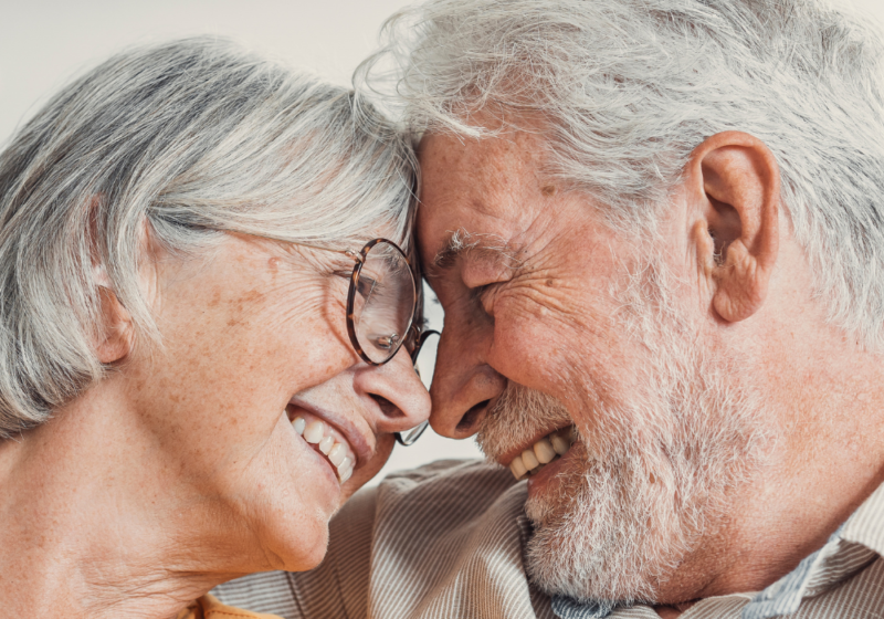 Home interior, elderly couple, foreheads touching in close-up, soft afternoon light, documentary style, people.