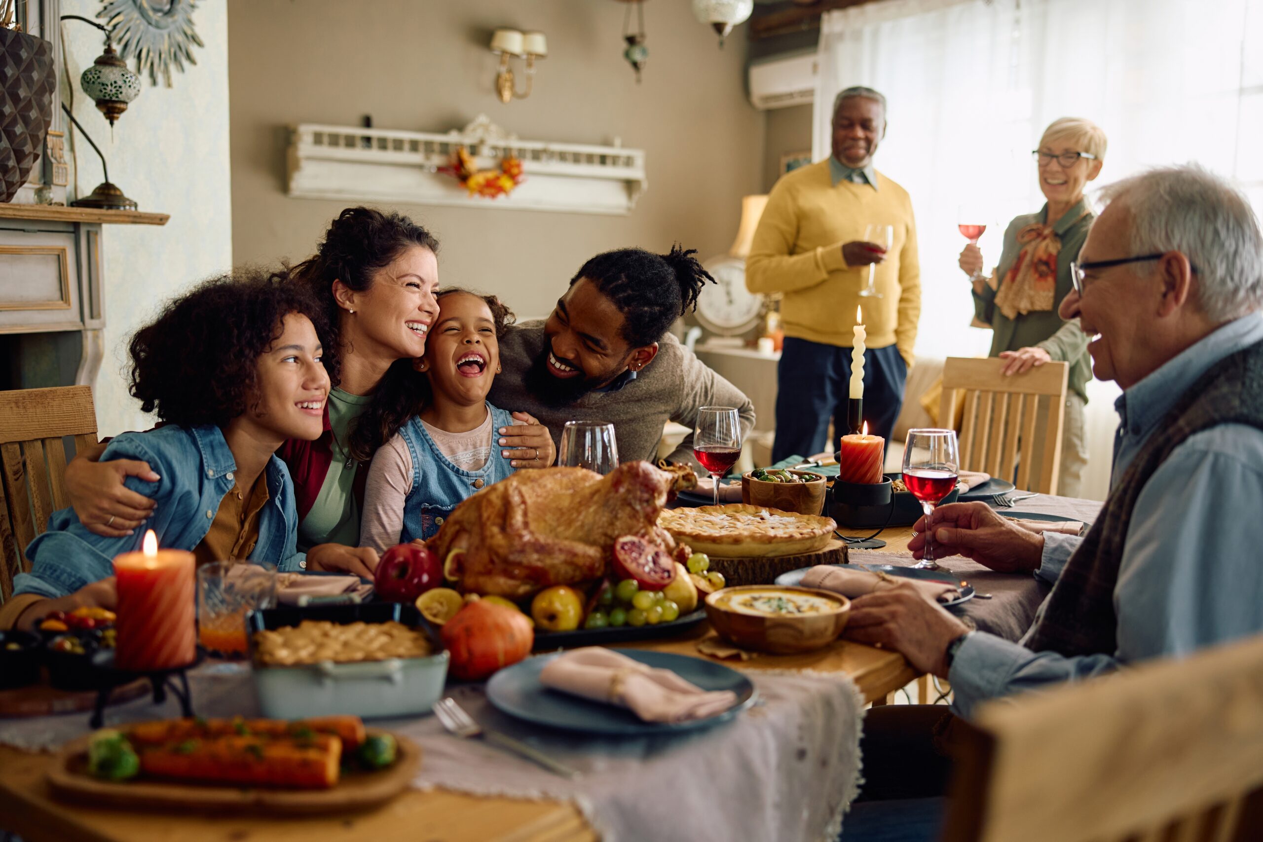 Dining room, festive meal centerpiece, food-laden table at dusk, warm lighting, documentary style, smiling family together.