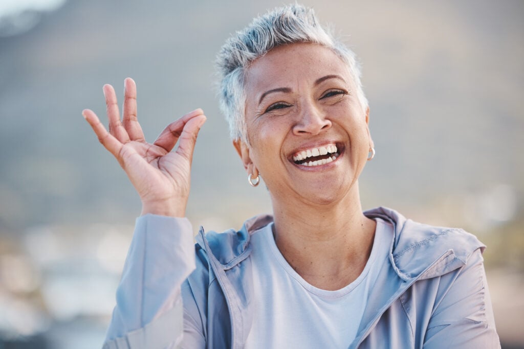 Outdoor park, older woman with hoop earrings, medium shot, soft daylight, editorial travel photo, people.