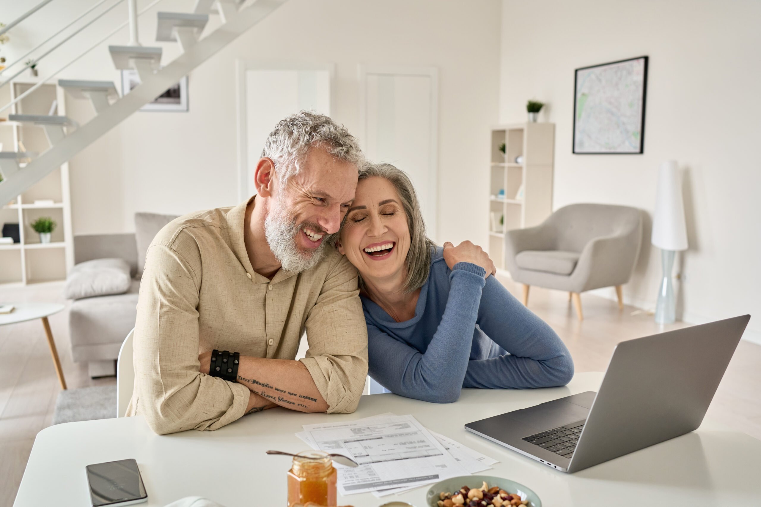 Bright modern living room, joyful couple with laptop, cozy close-up, daytime natural light, lifestyle photo, two people.